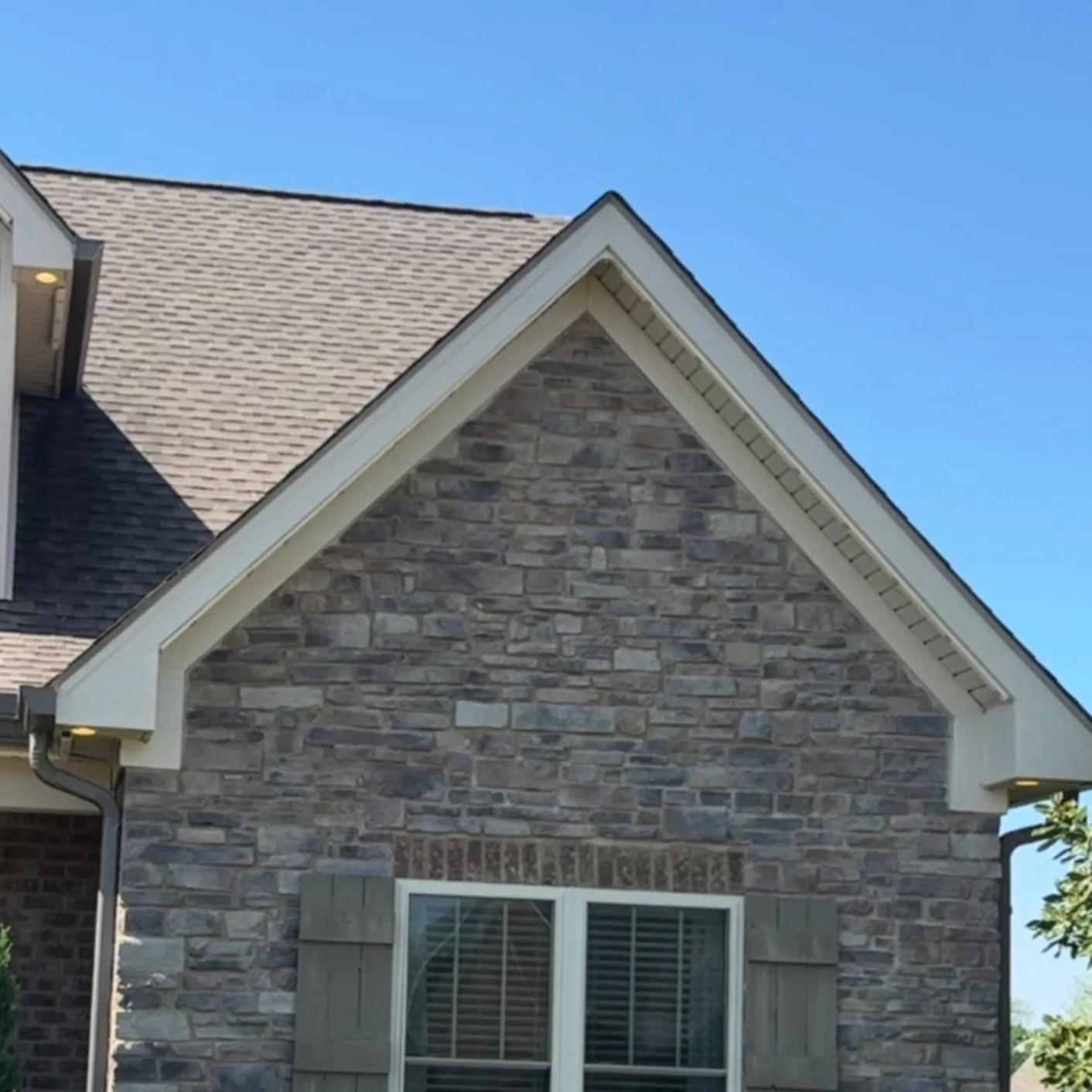 Daytime view of a brick gable with permanent light track tucked under the trim, barely visible